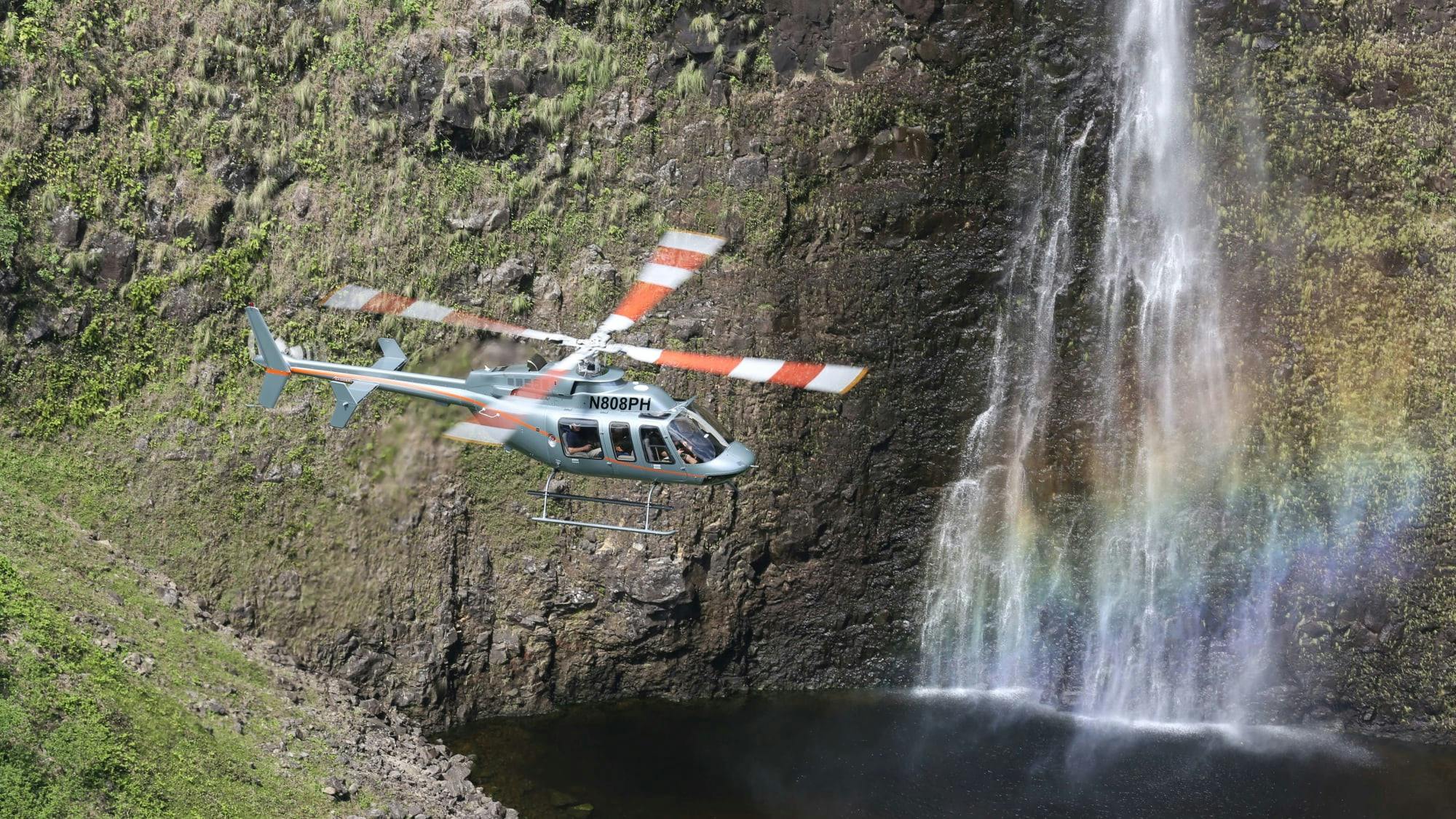 Helicopter flying next to waterfall