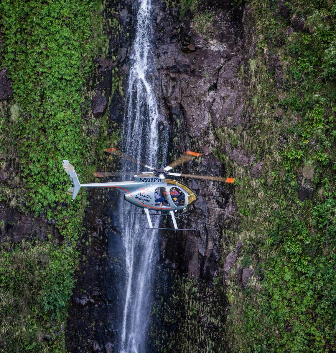 MD 500 flying along Hilo waterfall