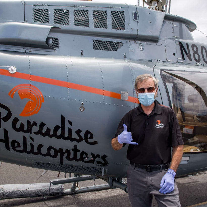 Cal wearing a protective mask in front of helicopter 
