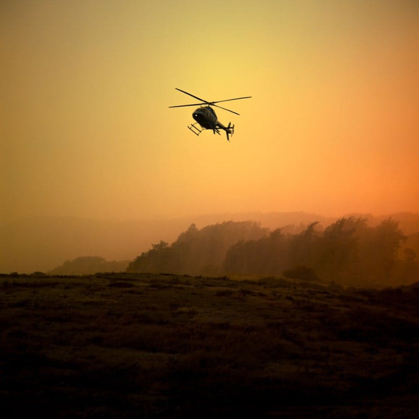 Helicopter flying with an orange background 