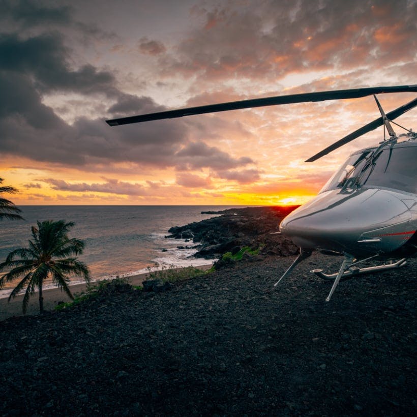 Helicopter parked with the beach and the sunset in the background