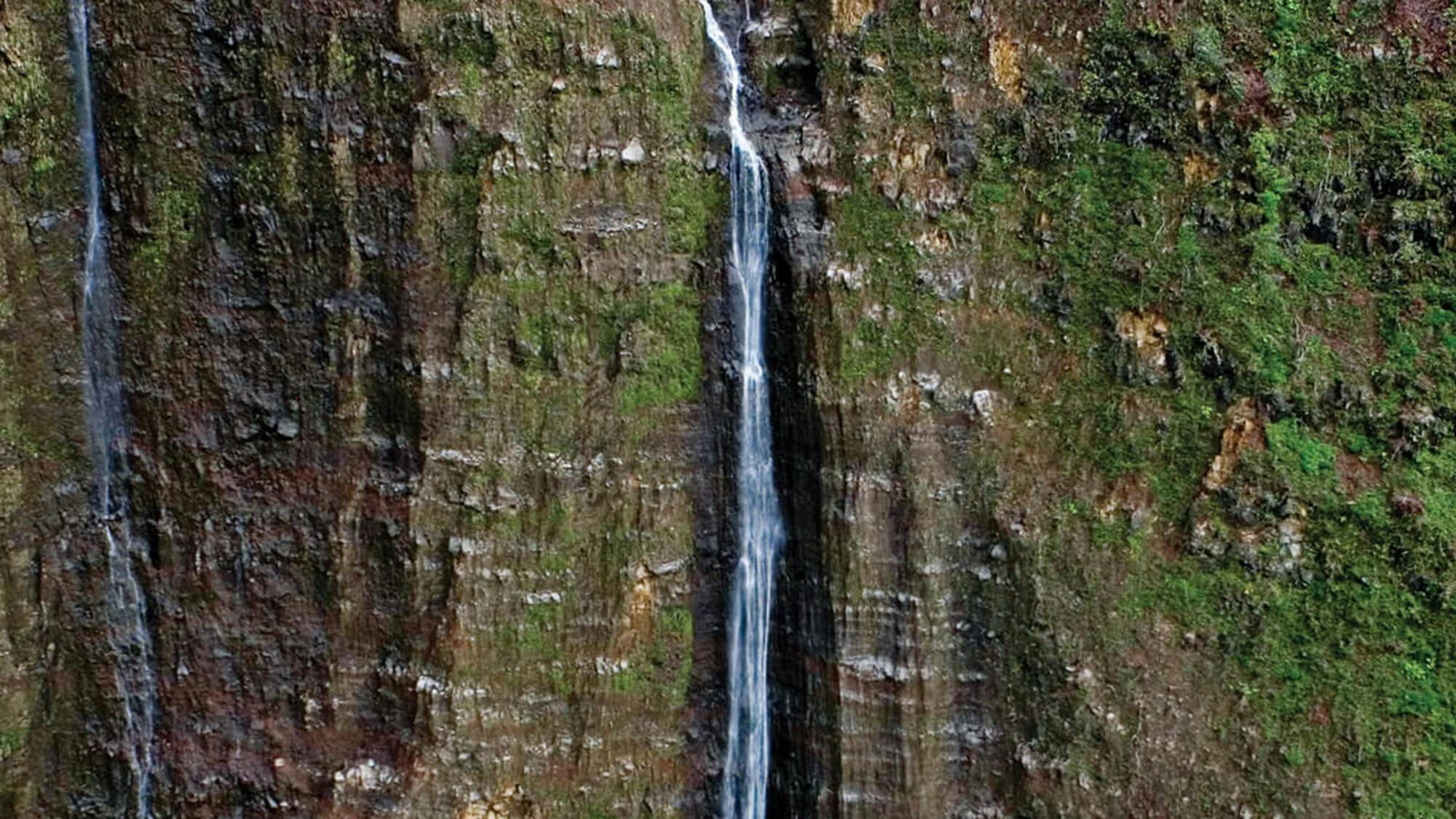 helicopter flying by a waterfall