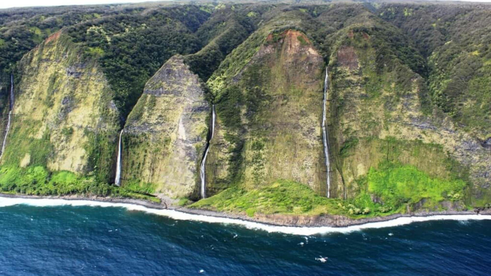 Beach view of cliffs and waterfalls on Kona