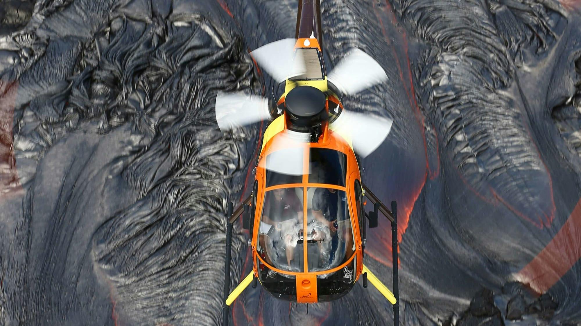 Magnum Helicopter flying over lava