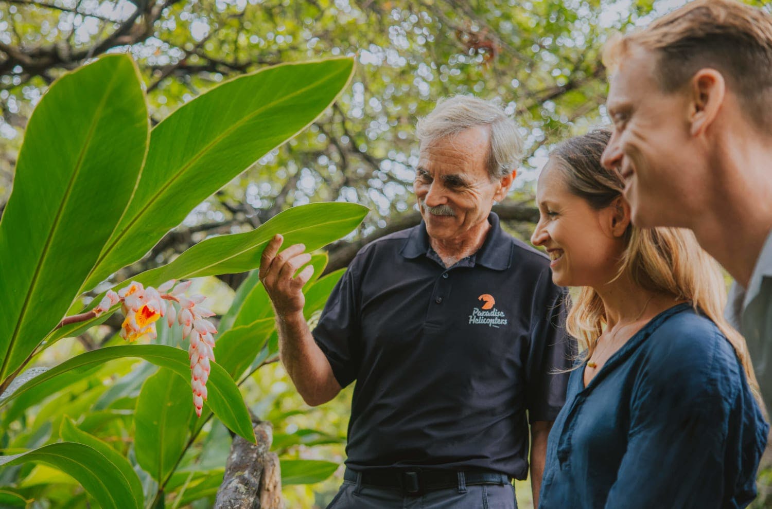 three people looking at Hawaiian plants 